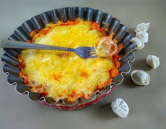 Запеченные пельмени в томатном соусе под сыром